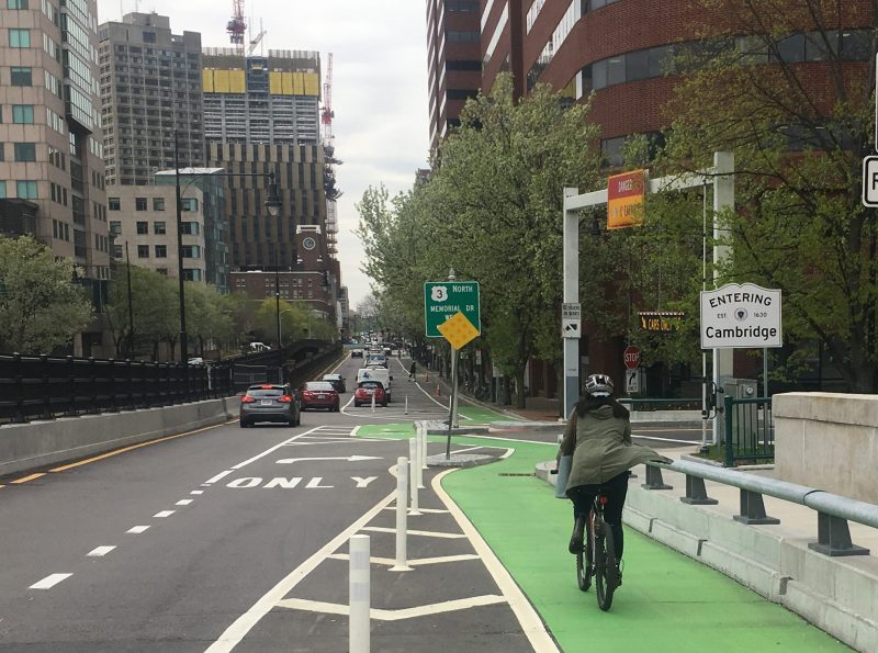 A cyclist enters Cambridge on the protected bike lane at the western end of the Longfellow Bridge in May 2019. Under plans to be implemented this fall, similar improvements will be made for the eastbound lanes of Cambridge's Main Street.