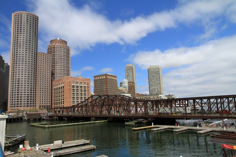 The old Northern Avenue Bridge and the downtown Boston skyline in 2013. Photo by Wikimedia Commons user Ingfbruno.