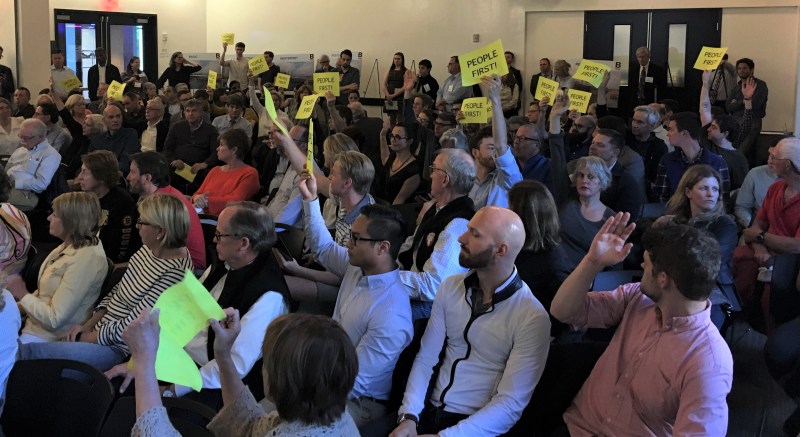 Supporters of a car-free replacement bridge hold up signs at a public hearing on the Northern Avenue Bridge project on June 3, 2019. Photo by Christian MilNeil.