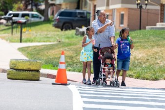 Lisa Ford walks her grandchildren, Cannon Castell; Jada Ford; and Chastity Castell, across a temporary crosswalk.