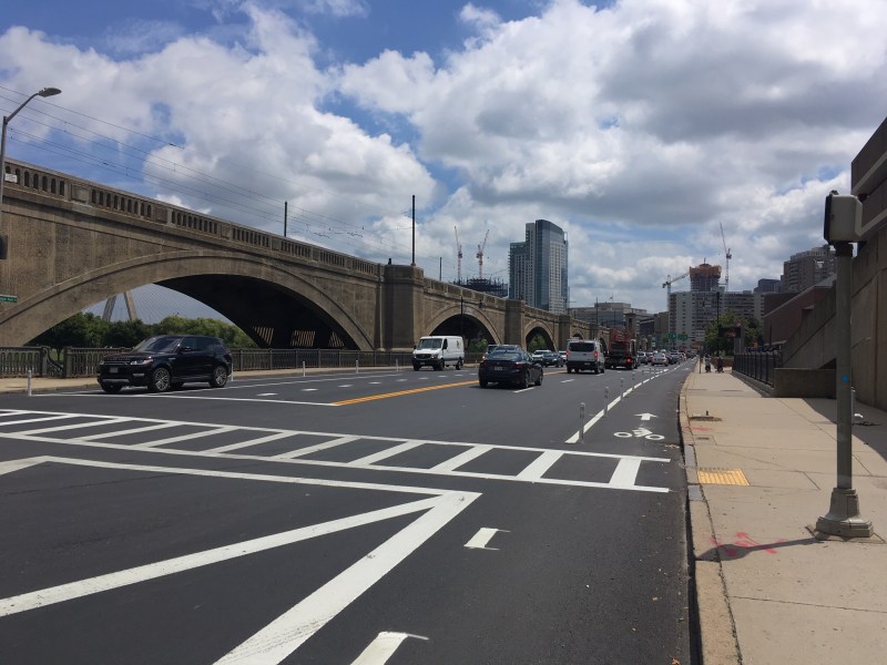 New flexpost-protected bike lanes have been installed on the Craigie Bridge in front of the Boston Museum of Science, seen in this August 8 photograph looking south towards Boston.