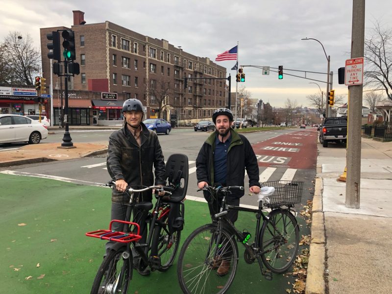 Somerville planners Brad Rawson (left) and Justin Schreiber in front of the city's new bus lanes at the top of Winter Hill on November 22, 2019.