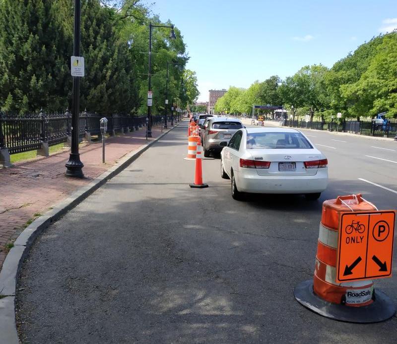 A (very) temporary protected bike lane appeared on Charles Street next to the Public Garden at the end of May, as seen in this May 31 photo. The barrels have since been removed, and Boston's planned "healthy streets" network of protected bike lanes around downtown Boston remains incomplete. Photo courtesy of Amir Tadmor.