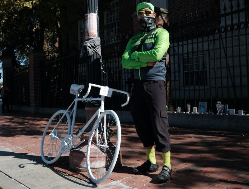 Peter Cheung with a ghost bike memorial to Darryl Willis, who was killed in Harvard Square in August 2020.