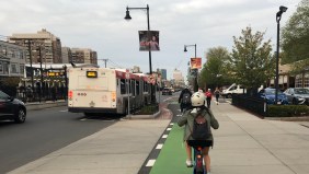 Bike traffic on the Commonwealth Avenue protected bike lane next to the MBTA's Babcock Street Green Line station.